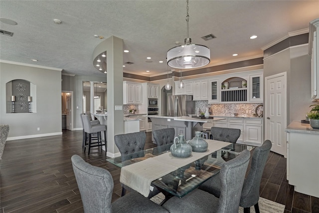 13625 Lakeside Place Dr, Willis, TX 77318 - dining area with crown molding, visible vents, baseboards, and wood finish floors