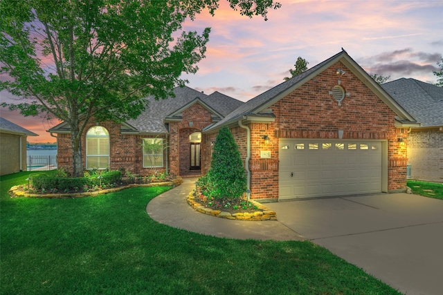 13625 Lakeside Place Dr, Willis, TX 77318 - traditional-style house with a lawn, an attached garage, brick siding, and driveway
