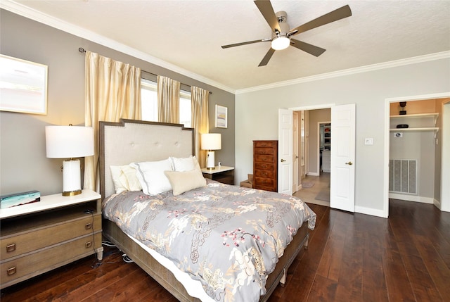 bedroom featuring baseboards, ornamental molding, dark wood finished floors, and visible vents