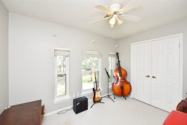 exercise room featuring baseboards, carpet flooring, and ceiling fan