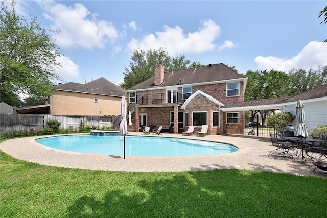 view of swimming pool featuring a patio, a fenced backyard, a pool with connected hot tub, and a yard