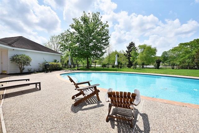 view of pool with a fenced in pool, fence, a patio, and a lawn