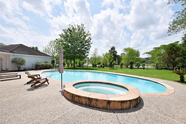 outdoor pool with a lawn, an in ground hot tub, and a patio area