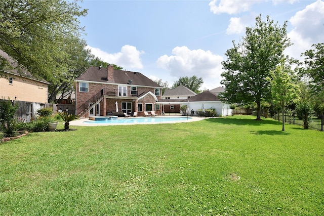rear view of property with brick siding, a fenced backyard, a fenced in pool, a chimney, and a yard