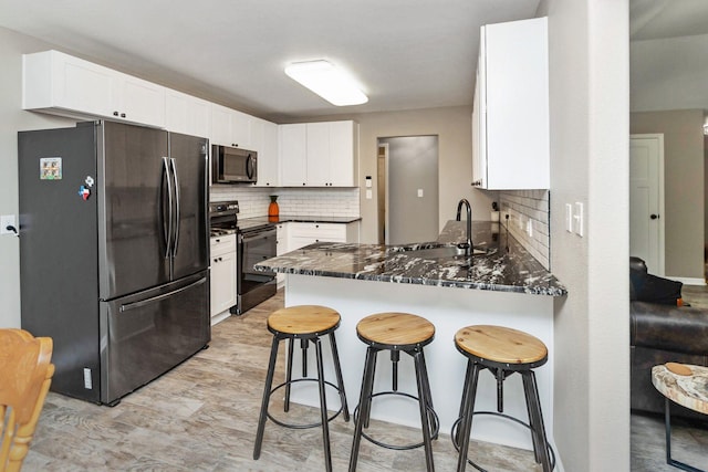 3300 Michelle Ave, Vidor, TX 77662 - kitchen with appliances with stainless steel finishes, tasteful backsplash, a sink, a peninsula, and white cabinetry