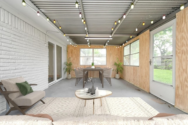 sunroom with track lighting, concrete floors, and a wealth of natural light