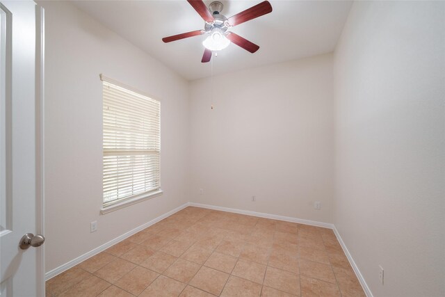 empty room featuring ceiling fan and baseboards
