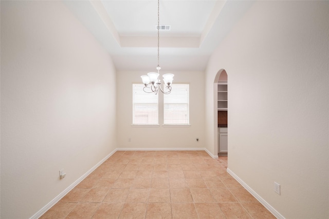empty room with an inviting chandelier, arched walkways, baseboards, and visible vents