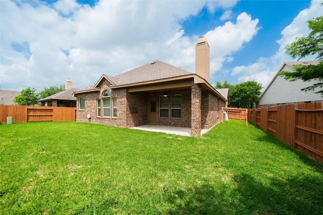 back of property featuring a patio, a fenced backyard, brick siding, and a chimney