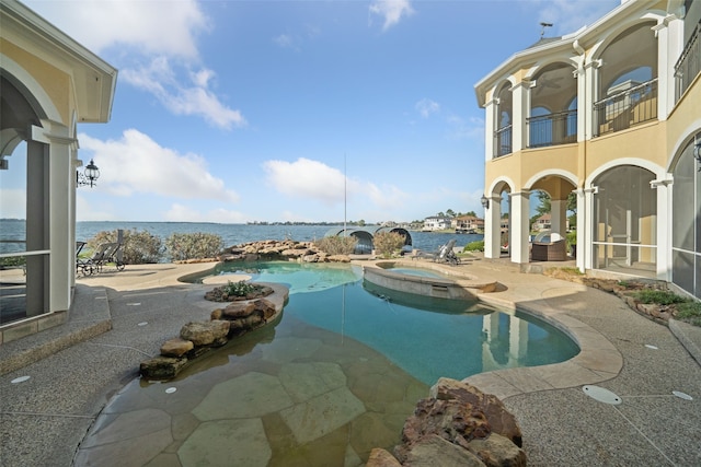 view of pool with a water view, a pool with connected hot tub, and a patio area