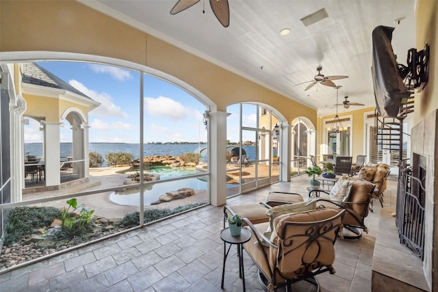 sunroom with a water view, a notable chandelier, and visible vents