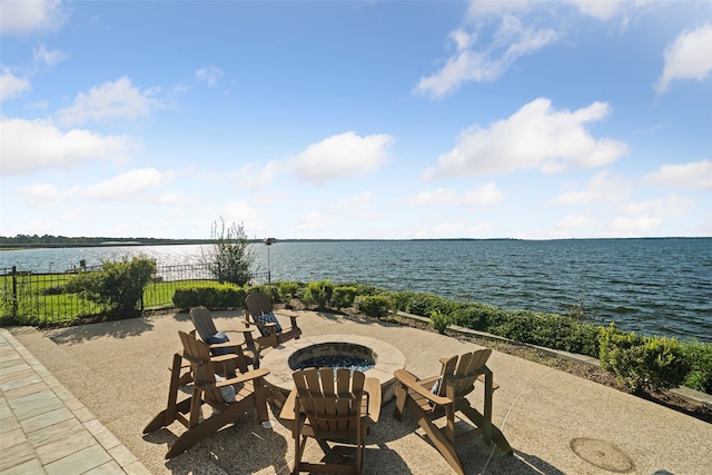 view of patio / terrace with a water view, an outdoor fire pit, and fence