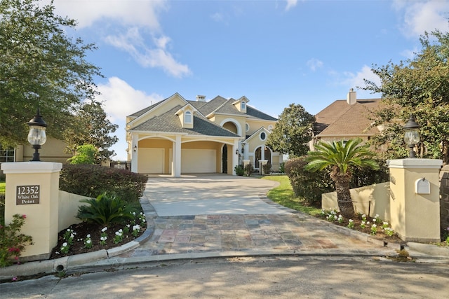 view of front of house with an attached garage, concrete driveway, and stucco siding