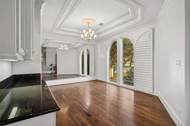 unfurnished living room with an inviting chandelier, crown molding, dark wood-type flooring, and visible vents