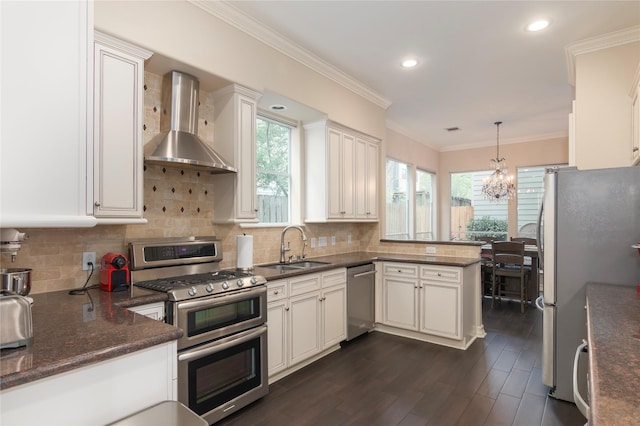 1900 Vermont St Unit B, Houston, TX 77019 - kitchen with appliances with stainless steel finishes, wall chimney exhaust hood, healthy amount of natural light, a peninsula, and ornamental molding
