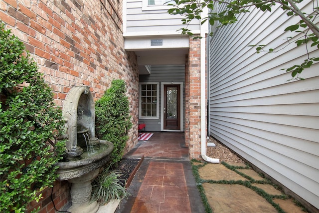 view of exterior entry featuring brick siding