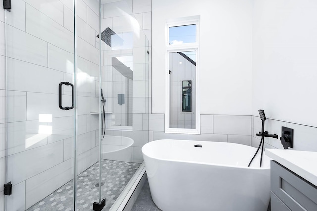 1707 Milby St, Houston, TX 77003 - bathroom featuring a freestanding tub, tile walls, vanity, and a stall shower