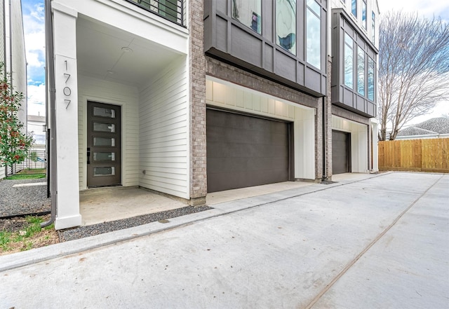 1707 Milby St, Houston, TX 77003 - entrance to property with concrete driveway, brick siding, fence, and a garage