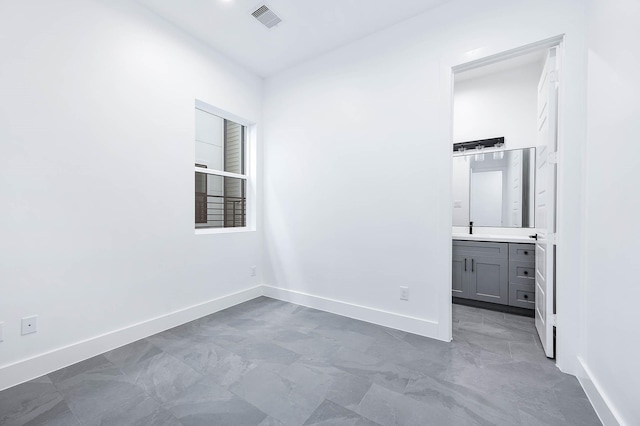 1707 Milby St, Houston, TX 77003 - unfurnished bedroom featuring visible vents, connected bathroom, and baseboards