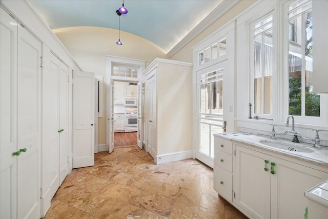 2614 Stanford St, Houston, TX 77006 - bathroom featuring a sink, vaulted ceiling, and baseboards