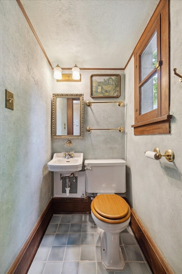 2614 Stanford St, Houston, TX 77006 - half bath featuring ornamental molding, toilet, a textured ceiling, a textured wall, and a sink