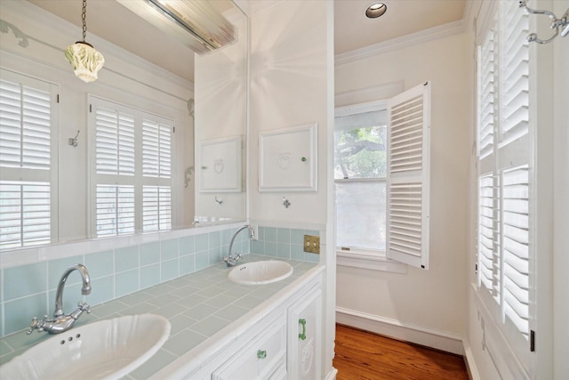2614 Stanford St, Houston, TX 77006 - full bathroom featuring baseboards, crown molding, tasteful backsplash, double vanity, and wood finished floors