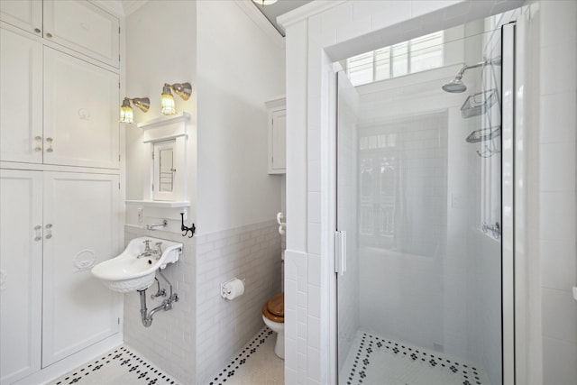 2614 Stanford St, Houston, TX 77006 - full bath with a shower stall, toilet, tile walls, a wainscoted wall, and tile patterned floors