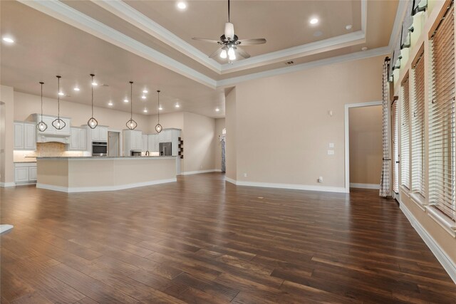 15306 Guava Vis, Conroe, TX 77302 - unfurnished living room featuring a ceiling fan, ornamental molding, dark wood-style floors, recessed lighting, and baseboards