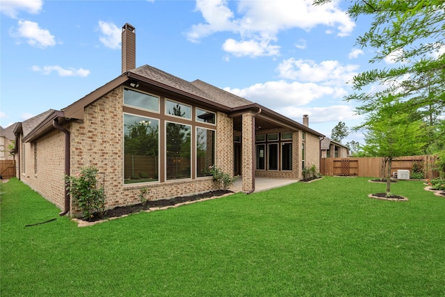 15306 Guava Vis, Conroe, TX 77302 - back of house featuring brick siding, a chimney, and a patio area