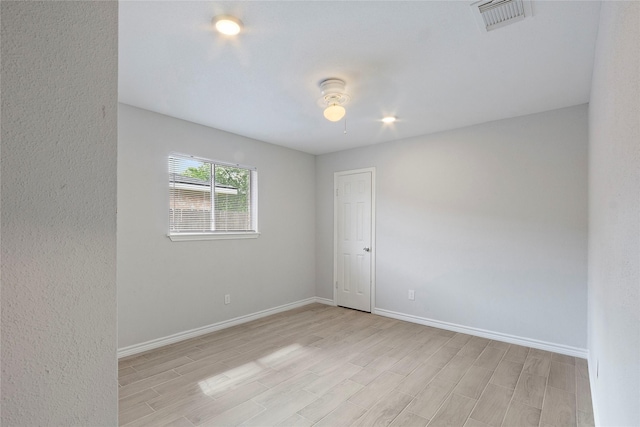 spare room with visible vents, baseboards, and light wood-style floors