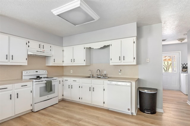 kitchen featuring white appliances, white cabinetry, under cabinet range hood, and a sink