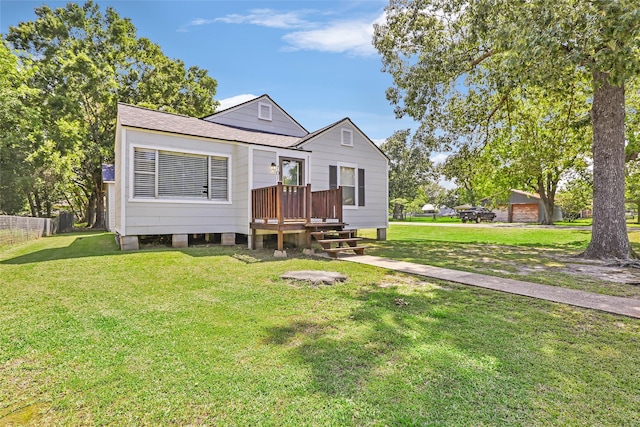 view of front of house featuring a shingled roof, fence, and a front yard