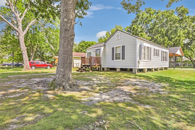view of side of home featuring a lawn and a wooden deck