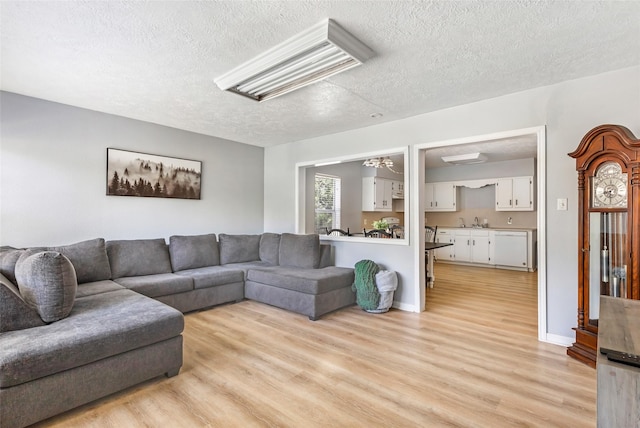 living room with a textured ceiling and light wood-style flooring