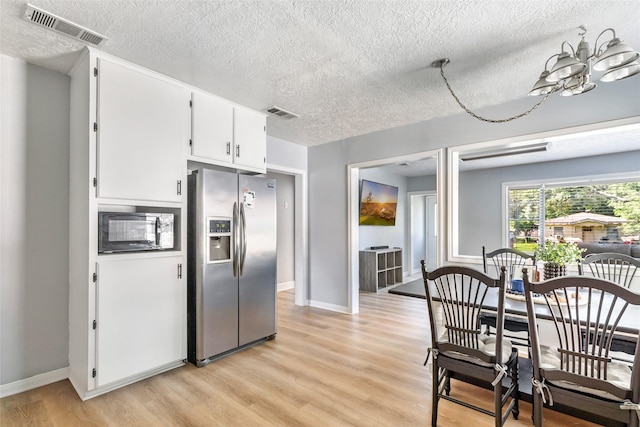 kitchen with stainless steel fridge, a textured ceiling, visible vents, and black microwave