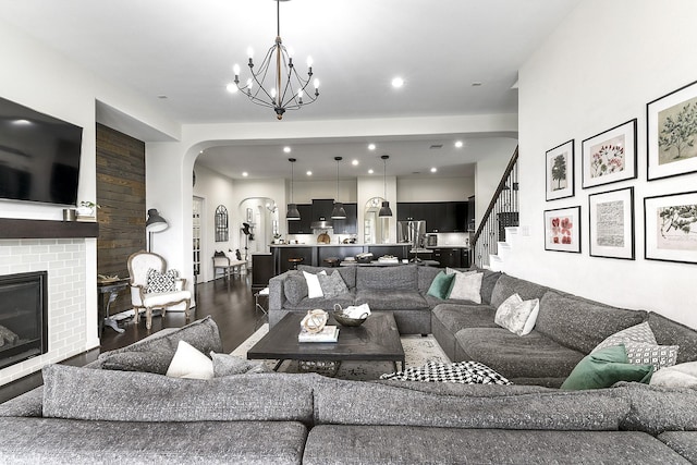 2502 Crossvine Dr, Katy, TX 77494 - living area featuring wood finished floors, a fireplace, recessed lighting, arched walkways, and a notable chandelier