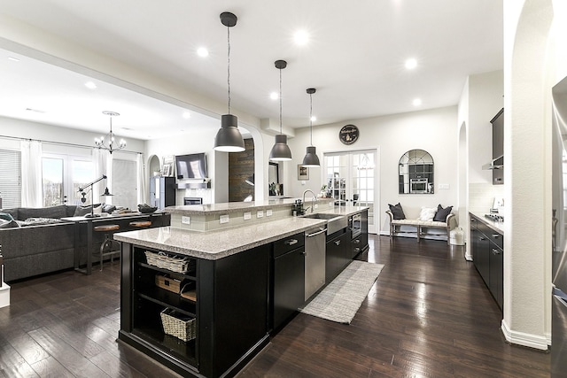 2502 Crossvine Dr, Katy, TX 77494 - kitchen with a large island with sink, a sink, open floor plan, dark cabinetry, and recessed lighting