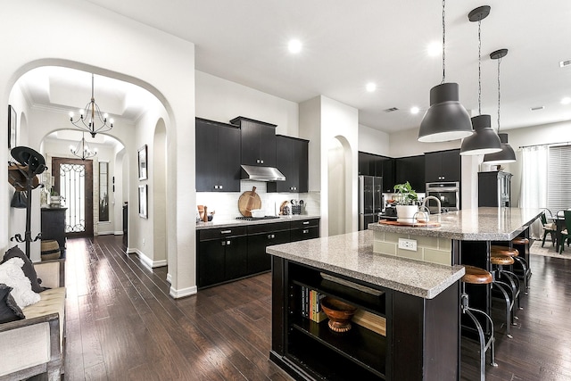2502 Crossvine Dr, Katy, TX 77494 - kitchen featuring dark cabinets, appliances with stainless steel finishes, and under cabinet range hood