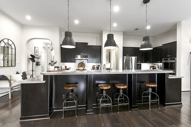 2502 Crossvine Dr, Katy, TX 77494 - kitchen featuring decorative backsplash, dark cabinetry, freestanding refrigerator, and dark wood-style floors