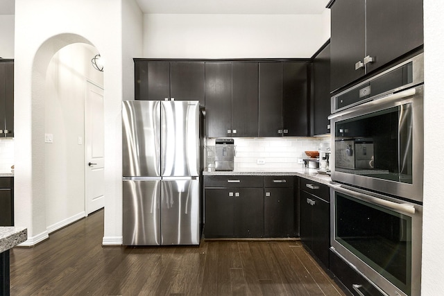 2502 Crossvine Dr, Katy, TX 77494 - kitchen with backsplash, appliances with stainless steel finishes, dark wood finished floors, baseboards, and light stone counters