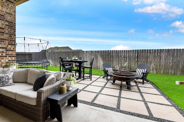 2502 Crossvine Dr, Katy, TX 77494 - view of patio with a fenced backyard, a trampoline, an outdoor fire pit, and outdoor dining space