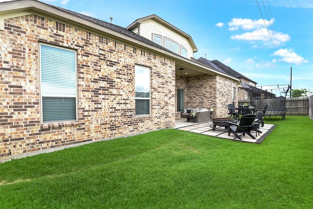 2502 Crossvine Dr, Katy, TX 77494 - rear view of house featuring fence, a trampoline, brick siding, a patio, and a yard