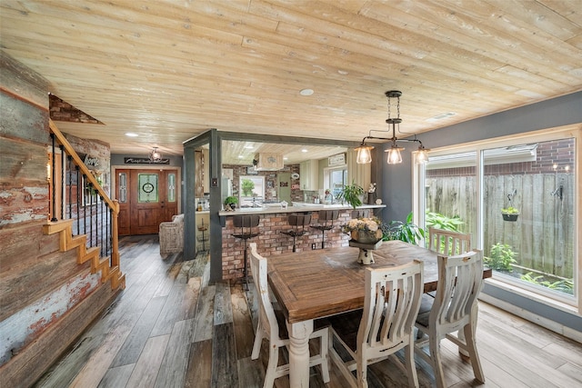 dining room with wood-type flooring, stairs, visible vents, and wood ceiling