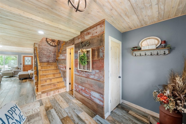 interior space with baseboards, wood ceiling, wood finished floors, and stairway