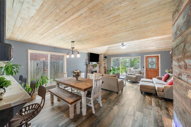 dining room with wood-type flooring, wooden ceiling, and a fireplace