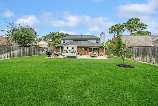 back of house with a lawn, brick siding, a chimney, and a patio area