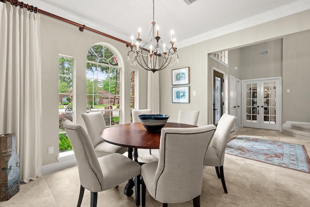 dining space with visible vents, ornamental molding, french doors, and an inviting chandelier