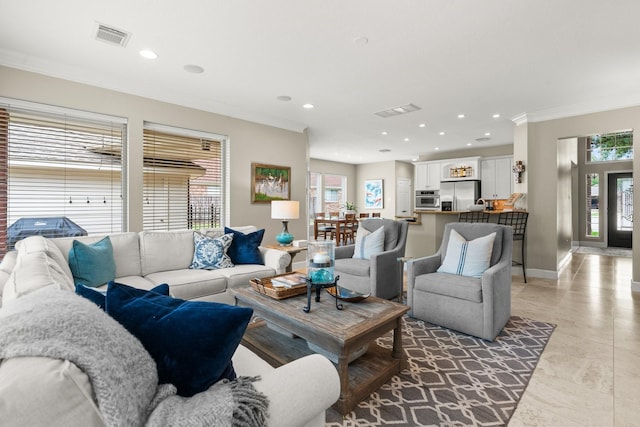 living room featuring visible vents, ornamental molding, baseboards, and recessed lighting