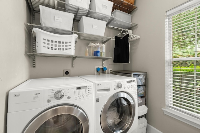 laundry area featuring independent washer and dryer, laundry area, plenty of natural light, and baseboards