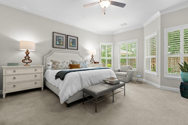 carpeted bedroom featuring crown molding, baseboards, ceiling fan, and visible vents